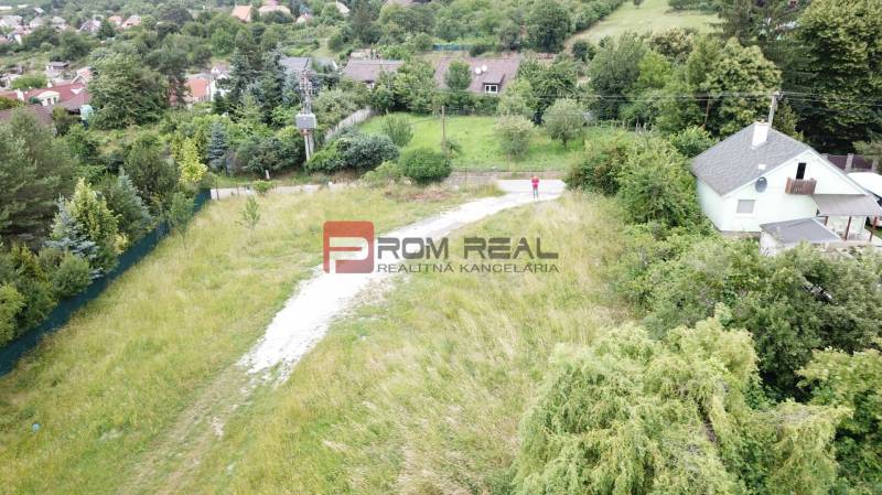 Pozemky pro bydlení v Mariance na Štúrově ulici, obklopené zelení a domy.