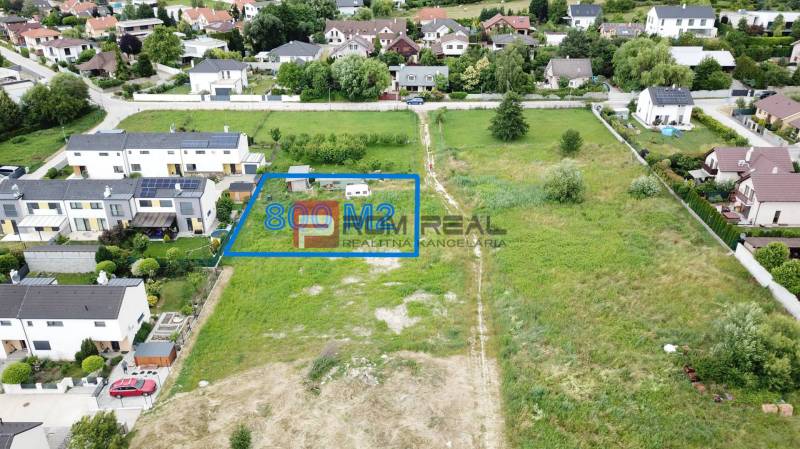 Pozemky - bydlení v Mariance na Na Ovsisku, s výměrou 800 m², obklopené zelení a domy.
