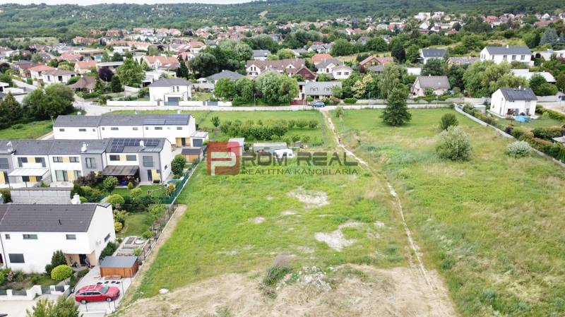 Pozemky na bydlení v Mariance na ulici Na Ovsisku obklopené zelenými zahradami a domy.