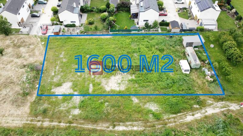 Pozemky - bydlení v Mariance, Na Ovsisku, 1600 m², s okolními moderními domy.