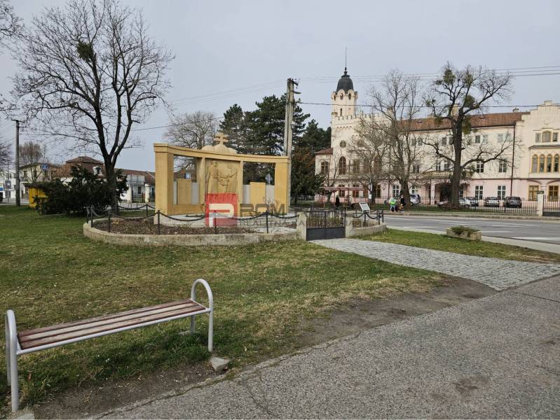 Socha s památníkem, lavička a historická budova v Ivance pri Dunaji na ulici Ivanka pri Dunaji.
