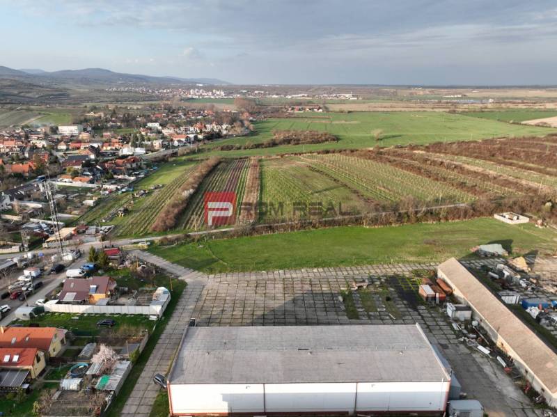 Letecký pohled na Vinosady z Pezinské ulice, obklopené vinicemi a výrobními prostory.