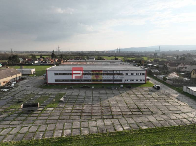 Výrobní prostory na Pezinské ulici ve Vinosadech obklopené zelenými plochami a cestami.
