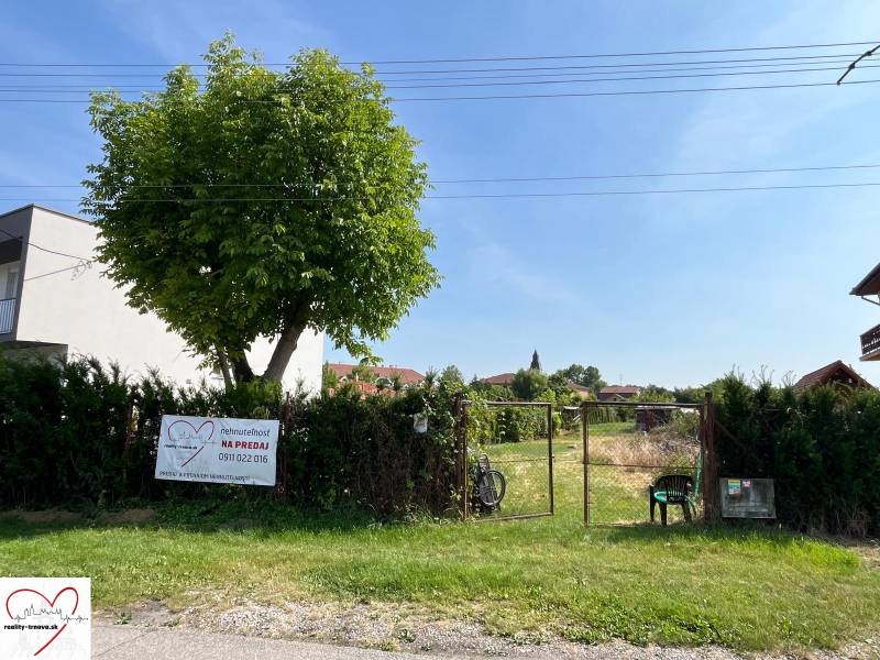 Pozemky - bydlení v obci Dolní Bar, oplocený pozemek se stromem a bránou.