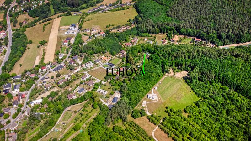 Letecký pohled na rekreační pozemky obklopené lesy a domy v Púchově, Vieska-Bezdedov.