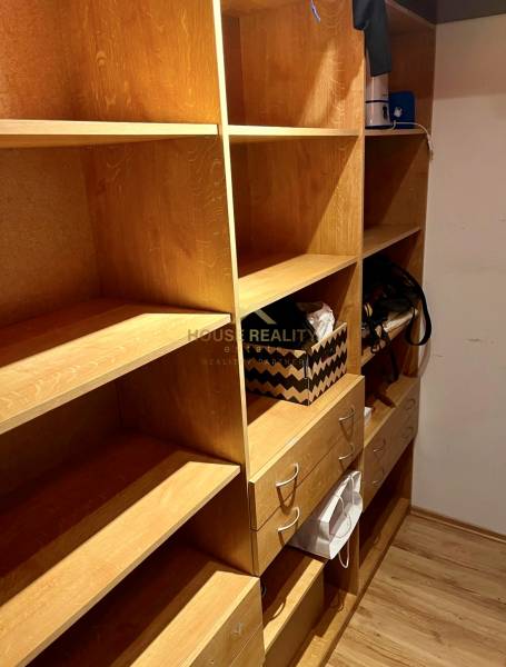 Úložný prostor s dřevěnými policemi a zásuvkami v 2-pokojovém bytě.