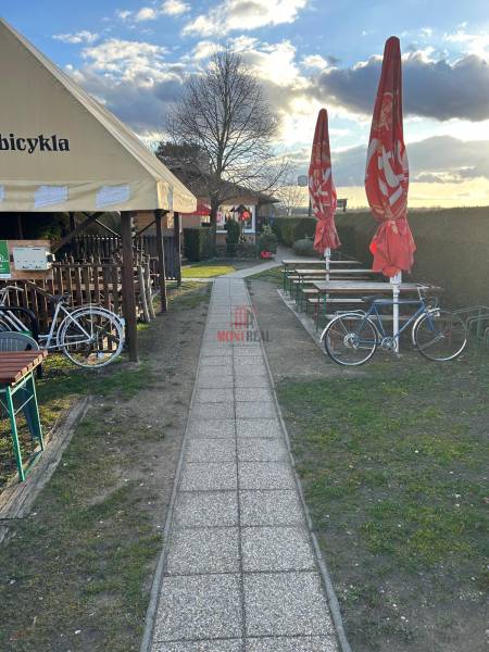 Chodník vedle gastro prostor s koly a slunečníky, Devínska Nová Ves, Devínské jezero.