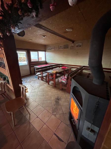 Útulná interiérová restaurace s krbem a dřevěným nábytkem, gastro prostory.
