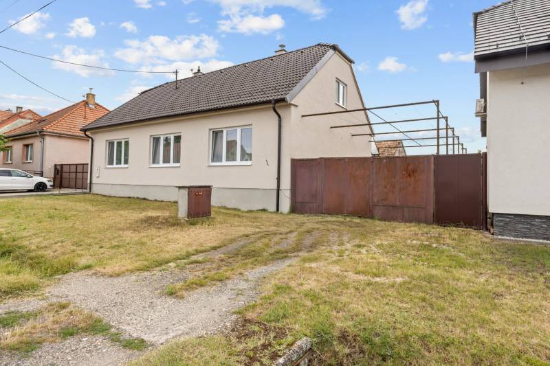 Rodinný dům na ulici Hoštáky v Sološnici se dvěma okny a velkou bránou.