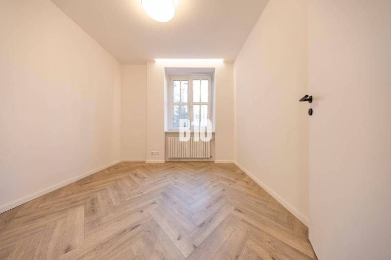 Světlý pokoj s parketovou podlahou a oknem ve 3-pokojovém bytě na ulici Benediktiho.
