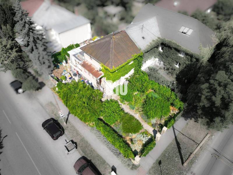 Rodinný dům v Bratislavě - Staré Město obklopený hustou zelení a stromy.