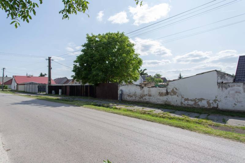 Ulice Športová v Gajaroch s pozemky na bydlení, vedle cesty a stromů.