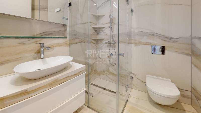 Luxusní koupelna se sprchovým koutem a designovým umyvadlem v 2pokojovém bytě.