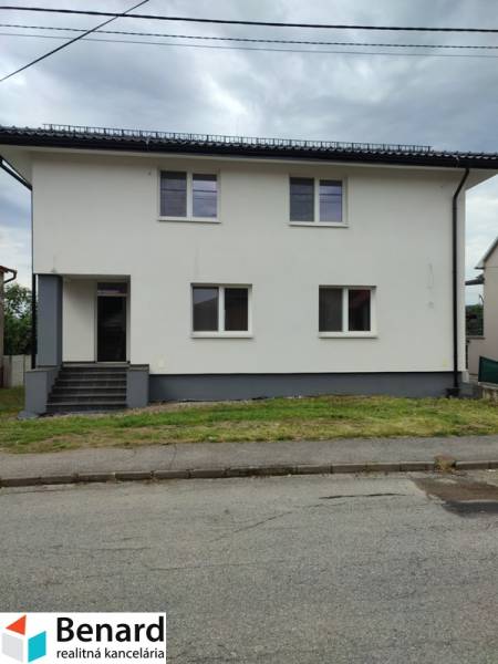 Rodinný dům na ulici Nezabudova v Sabinově s bílou fasádou a šedou střechou.