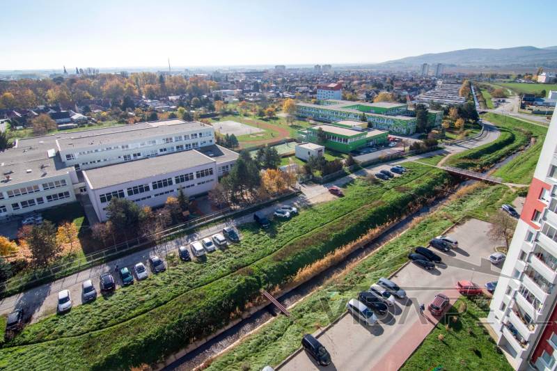 Výhled ze Svätoplukovy ulice v Pezinku na přilehlé školy a parkoviště u 3pokojového bytu.