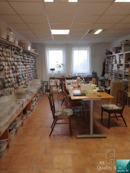 Interiér budovy se stoly a regály plnými materiálu na kreativní činnost.