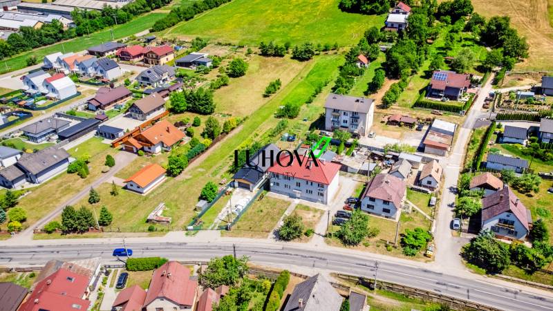 Letecký pohled na domy v Púchově s okolní zelení a silniční infrastrukturou.