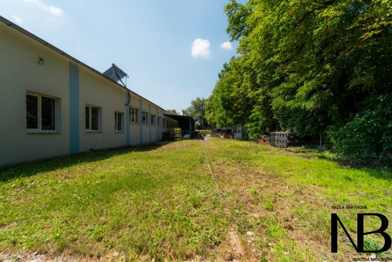 Výrobní prostory na Kasárenské ulici v Trenčíně obklopené zelení a prostranstvím.