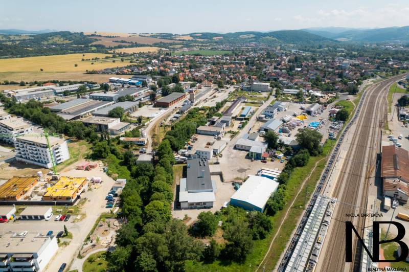 Letecký pohled na průmyslovou oblast na Kasárenské ulici v Trenčíně se sklady a halami.