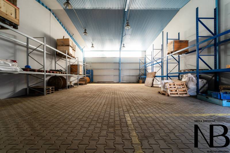Sklady a haly s regály a paletami pro skladování materiálů.
