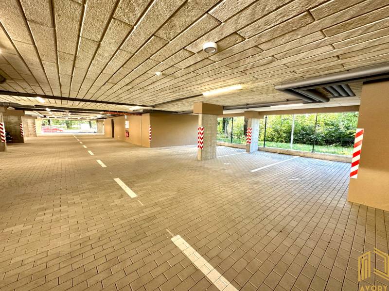 Garáže se světly, parkovacími místy a sloupy, Senica, Sadová, výhled na zeleň.
