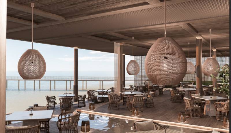 Luxusní restaurace s výhledem na oceán, stylová závěsná svítidla, komfortní sezení.