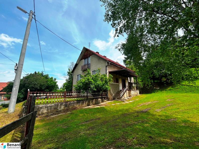 Rodinný dům ve Velké Lesné s rozsáhlým dvorem a stromovou vegetací.