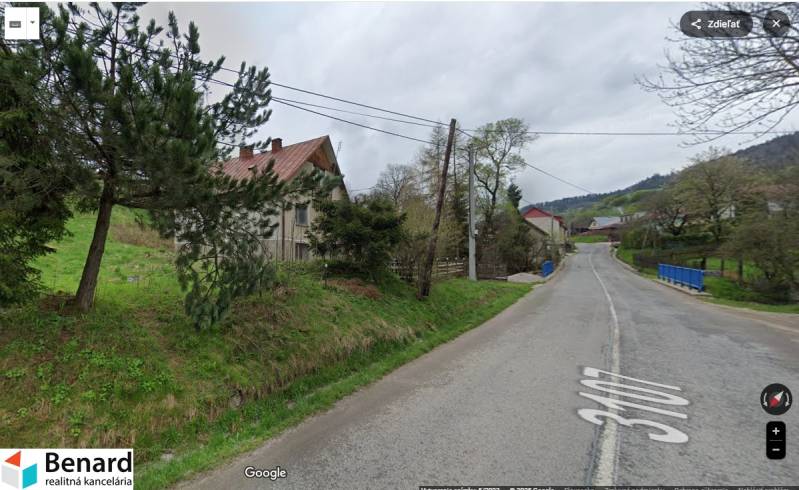 Cesta u rodinného domu v obci Velká Lesná, obklopená zelení a stromy.