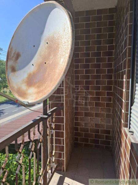 Balkon rodinného domu v Lovinobani, s kovovým zábradlím a satelitní anténou.