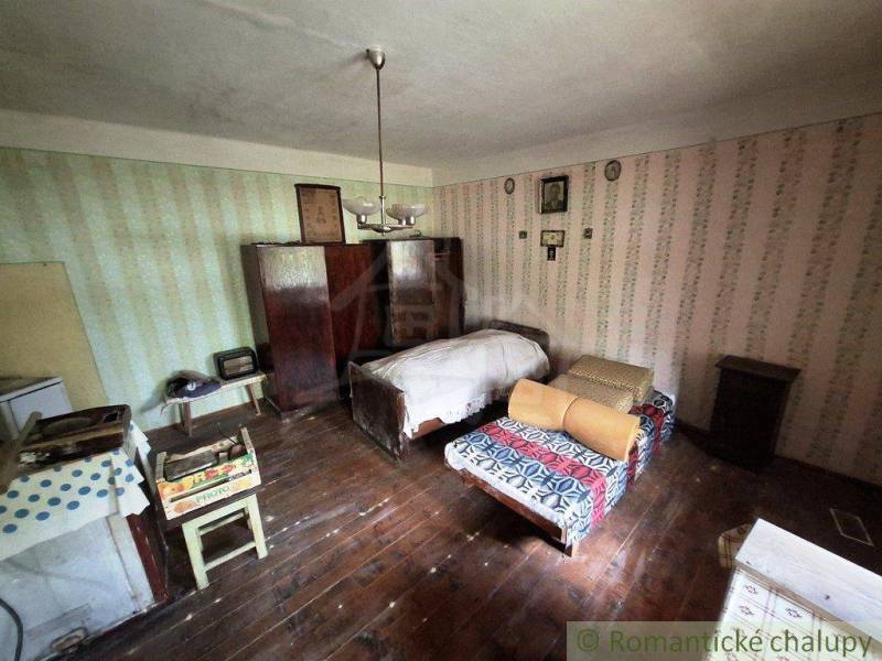 Retro pokoj v rodinném domě s dvěma postelemi a dřevěnou podlahou.