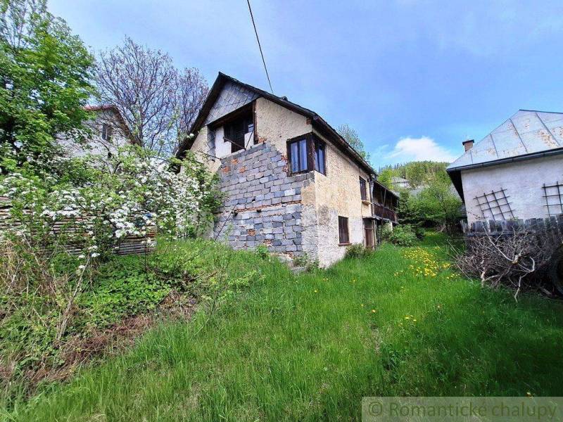 Starší rodinný dům ve vesnici Pohorelá obklopený zelení a přírodou.