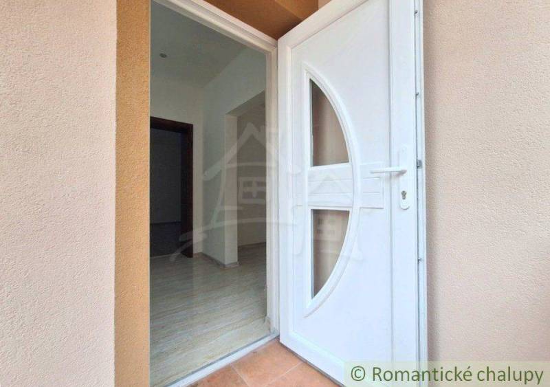 Vstupní dveře do rodinného domu v Komárně, s dlaždicovou podlahou a světlou chodbou.
