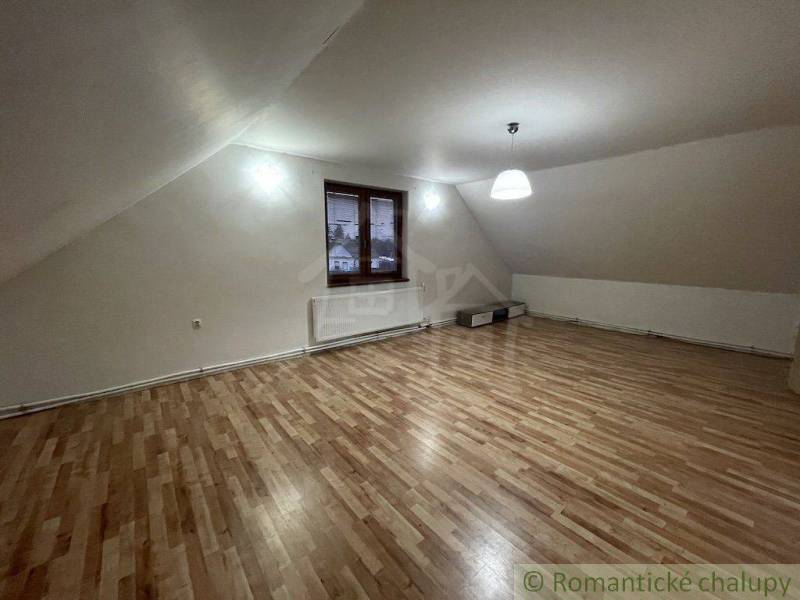 Podkrovní pokoj se šikmým stropem, osvětlení a výhled, rodinný dům, dřevěná podlaha.