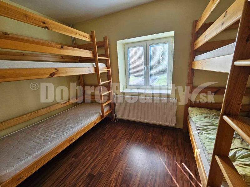 Dřevěné patrové postele v pokoji rodinného domu s dřevěnou podlahou.