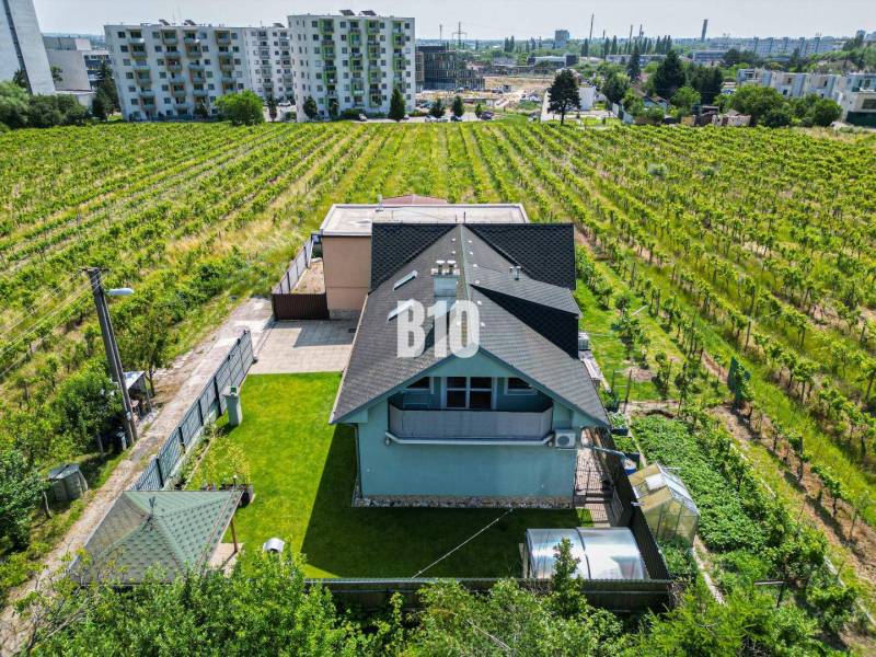 Rodinný dům v Bratislavě - Novém Městě obklopený vinicemi a nedalekými bytovými domy.