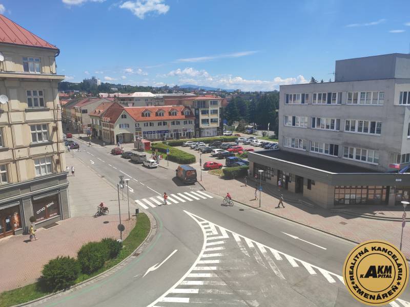 Ulice J. Kotáčka ve Zvolenu s kancelářemi, obchody a auty na parkovišti.