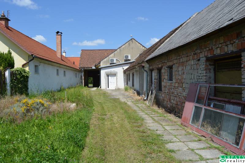 Exteriér poblíž obchodních prostor v Borském Svätém Juru se zahradou a budovami.