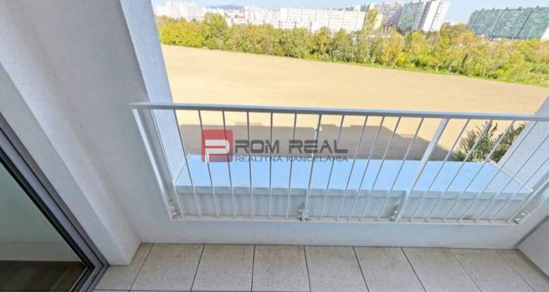 Balkon 2-pokojového bytu na Labutí ulici, Bratislava V s výhledem na zeleň a budovy.