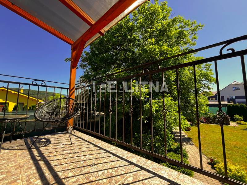 Balkon rodinného domu v Kriváni s výhledem na zahradu a modrou oblohu.