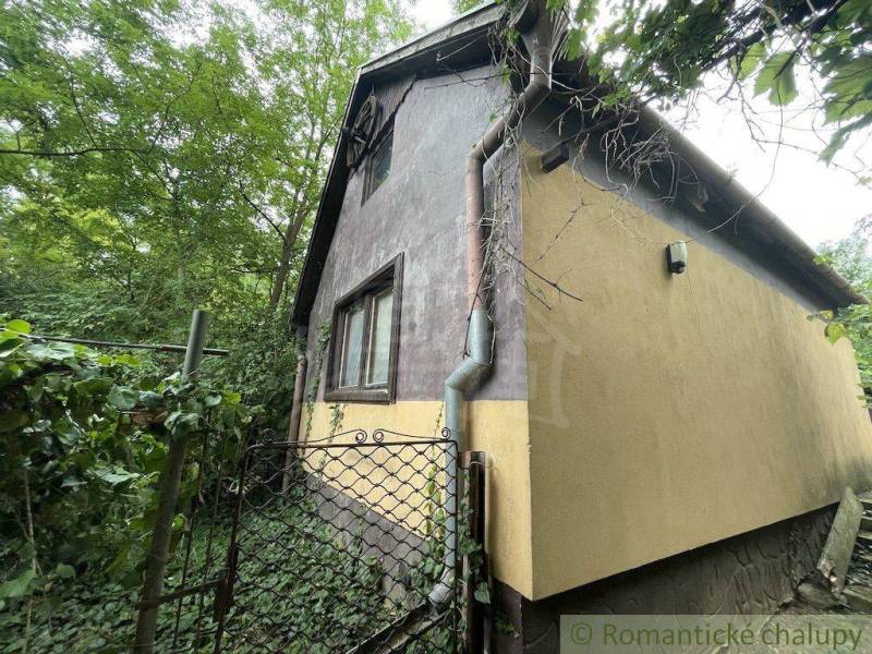 Rodinný dům v Branči obklopený zelení s bránou a okapovým systémem.