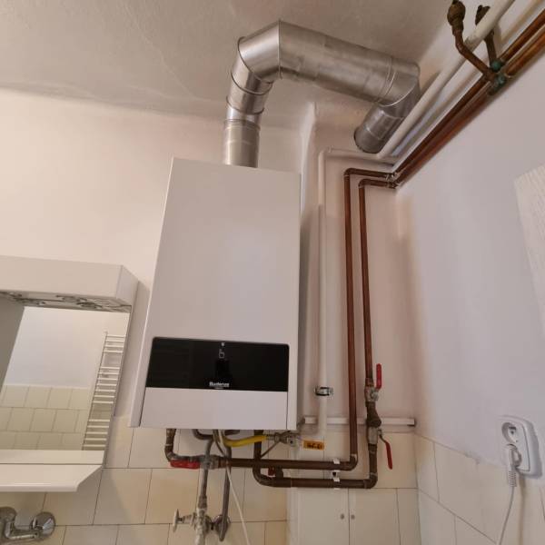 Plynový kotel s připojenými potrubími v interiéru rodinného domu.
