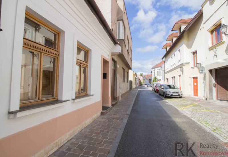 Ulice Vrátna v Košicích, Staré Město, s historickými fasádami a zaparkovanými auty.