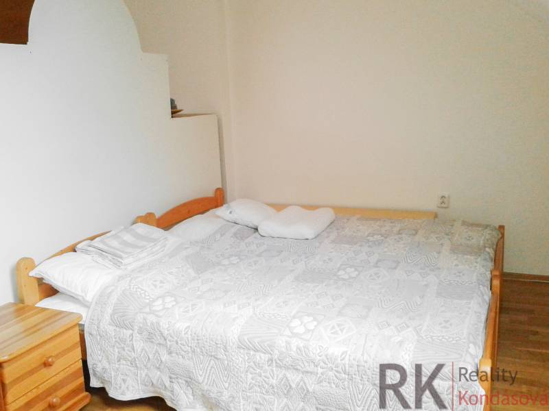 Světlá ložnice s manželskou postelí ve 2-pokojovém bytě.
