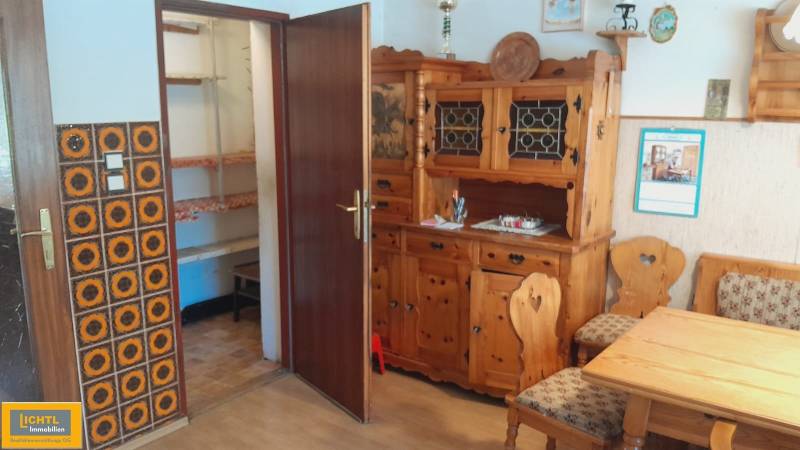 Dřevěný nábytek v interiéru rodinného domu s ornamentálním obkladem stěny.