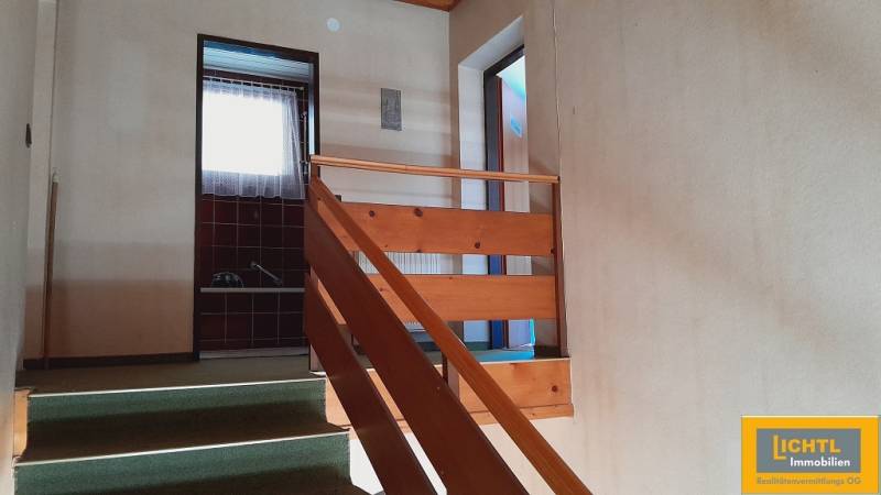 Interiér chodby se schody a dveřmi vedoucími do různých místností.