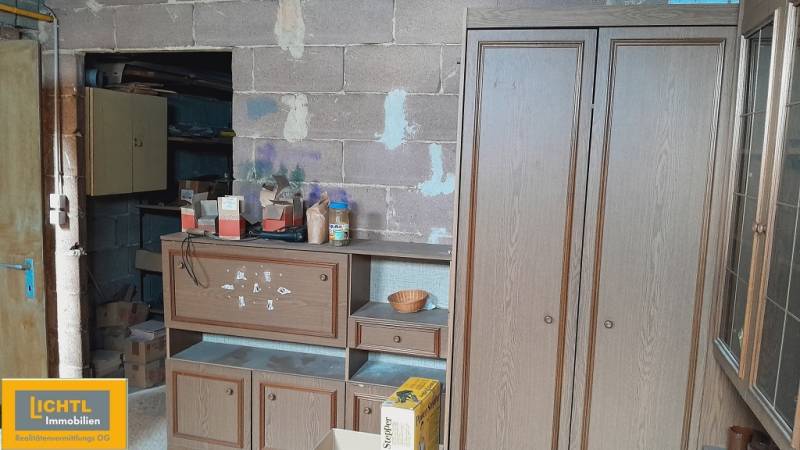 Interiér s policemi a krabicemi během výstavby bytů, různé materiály a nářadí.