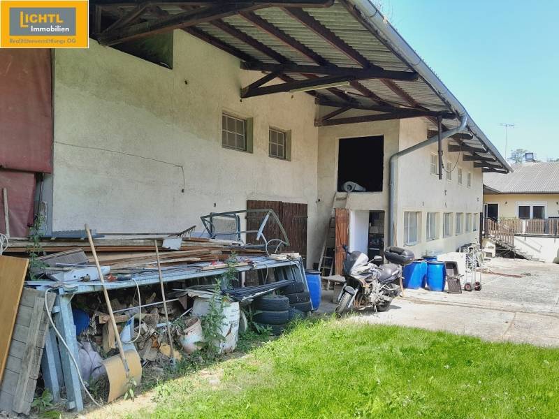 Exteriér gastro prostor v Grossinzersdorfu s uskladněnými materiály a motorkou na dvoře.