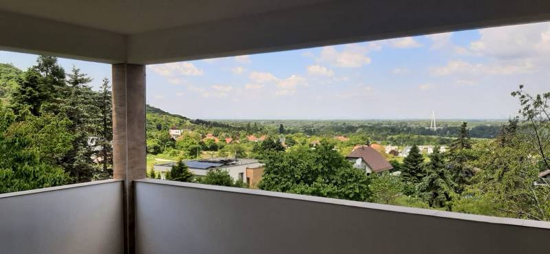 Výhled z vily na zeleň a město Hainburg an der Donau v dálce.