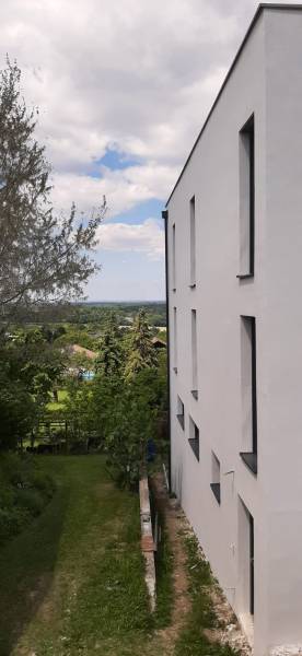 Bílá fasáda vily v Hainburgu an der Donau s výhledem na zahradu a stromy.