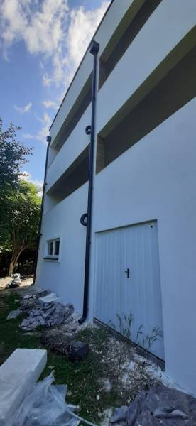Vila v Hainburgu an der Donau s bílou fasádou a šikmým trávníkem při vstupu.
